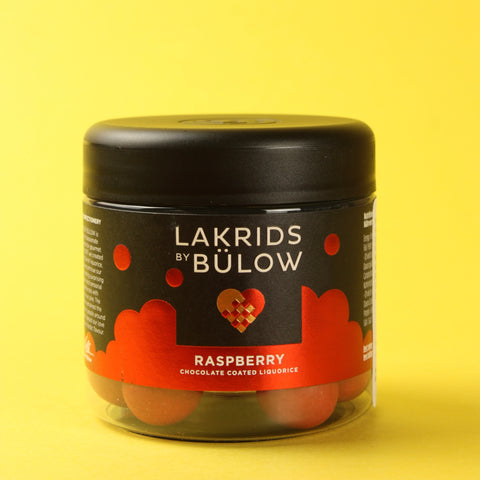 Jar of Lakrids by Bulow raspberry chocolate coated liquorice on a yellow background