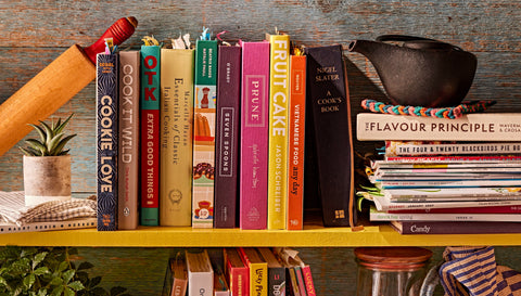 Cookbooks, food magazines and cooking implements on a shelf, Photography by Maya Visnyei