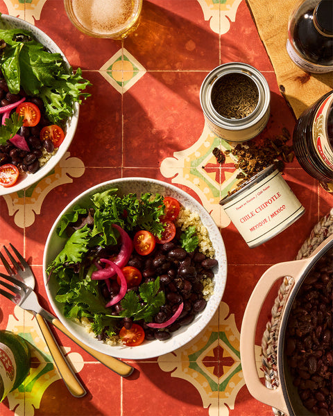 A bowl of smokey saucy black beans with quinoa and greens and Épices de cru chipotle