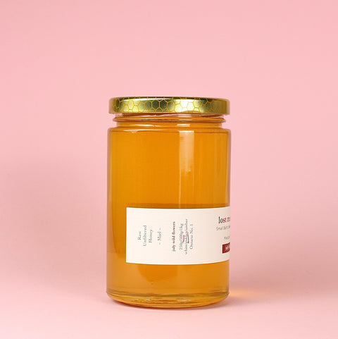 a jar of Lost Meadows honey on a pink background left side label
