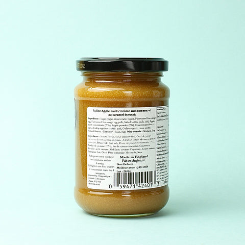 A jar of Thursday Cottage Toffee Apple Curd on a blue background ingredients panel