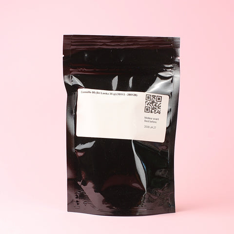 A bag of Épices de Cru Cinnamon Sticks 00 Back Panel on a pink background